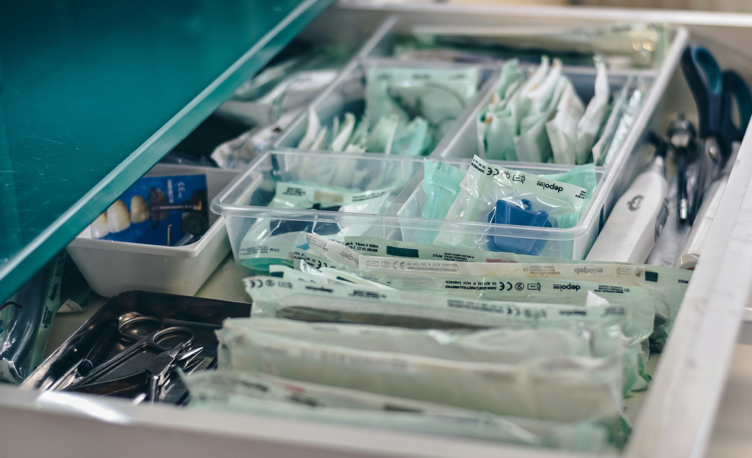 A well-organized medical drawer displaying various surgical instruments, packaged supplies, and sterilized tools, highlighting essential healthcare preparations.